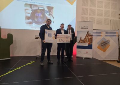 Laudator Felix Hapig mit den Geschäftsführern des Gewinners, Space Magic Aurich