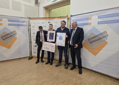 Laudator Felix Hapig mit den Geschäftsführern des Gewinners, Space Magic Aurich und Jürgen Brüna