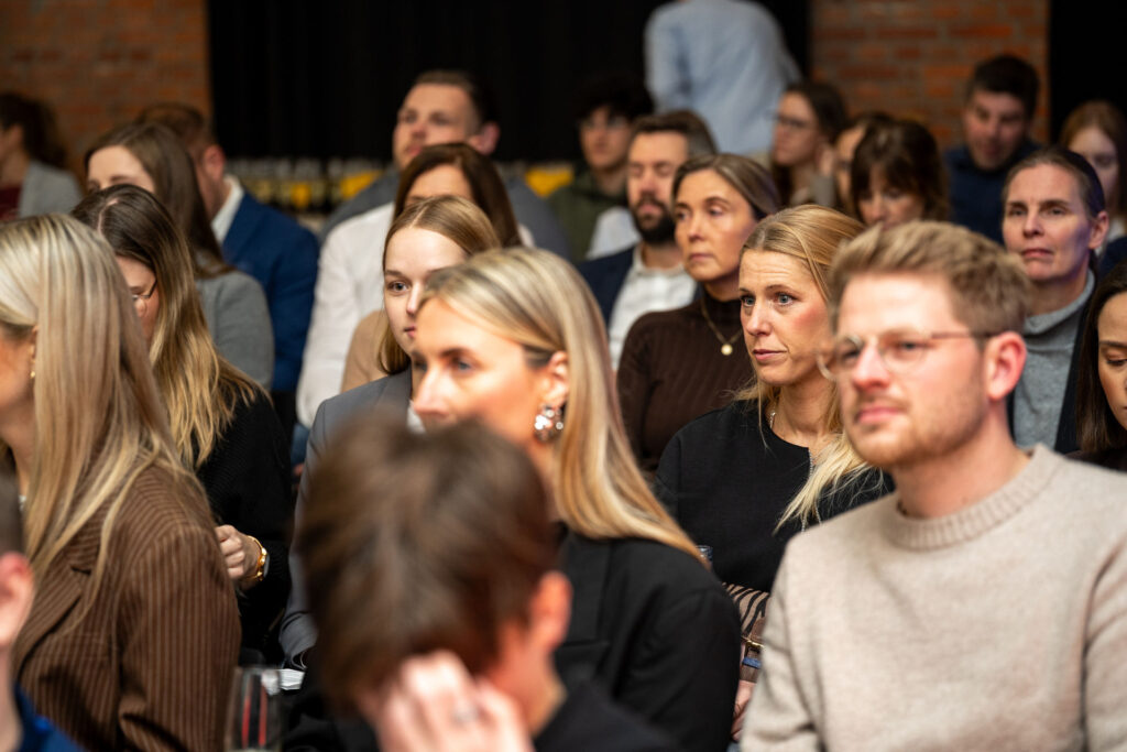 Lächelnde Gäste im Publikum der Preisverleihung 2025.
